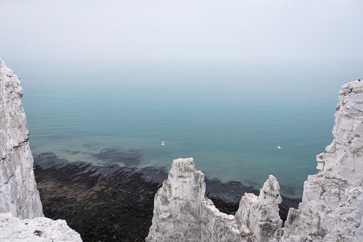 Rocky coastal cliffs descending into grey sea